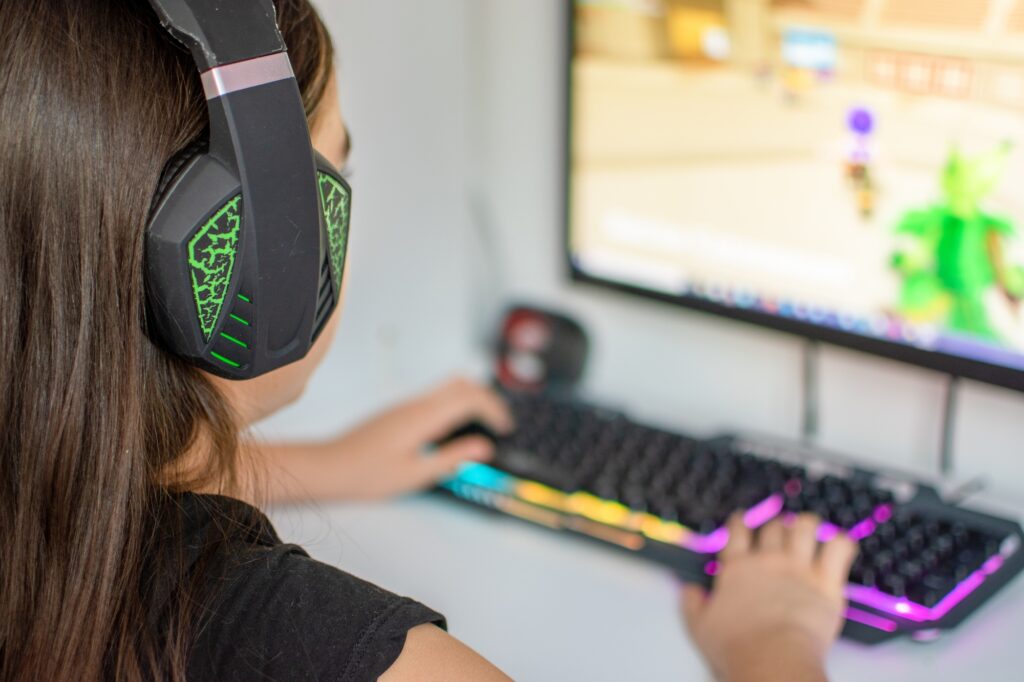 Girl playing video games on a desktop computer